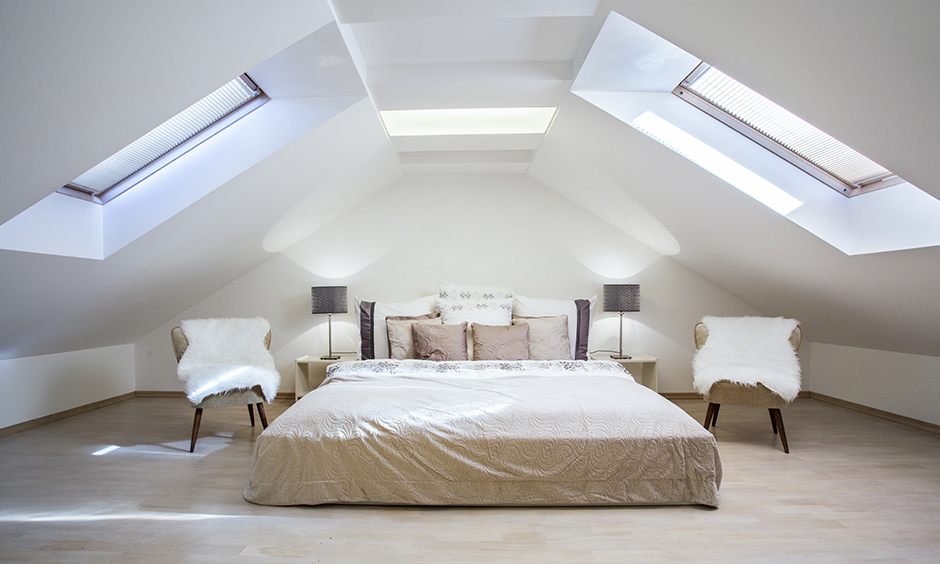 White attic bedroom in a triangular-sloped roof with skylight designed perfect romantic escape under the moonlight.