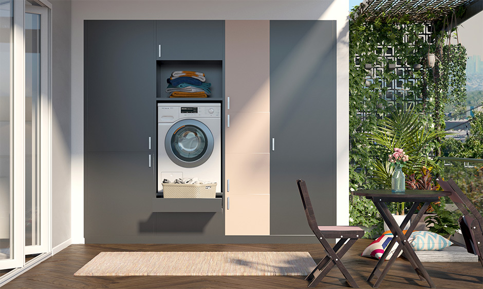 The large balcony laundry room has built-in space for a washing machine in the cabinet.