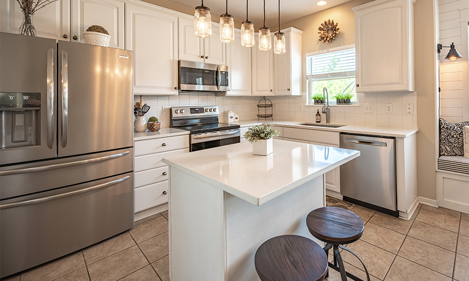 Contemporary french kitchen island in pastel hues with accent lights doubles up as a focal point.