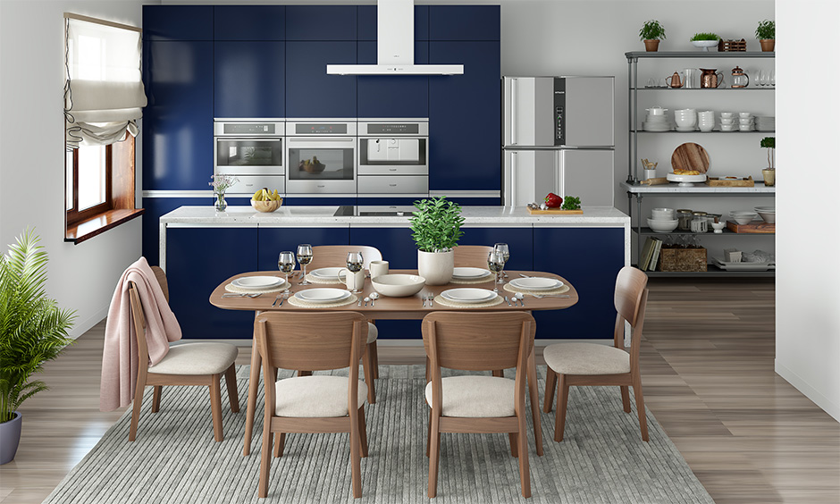 Indian style dining room in open kitchen with a rectangular table with a rounded edge