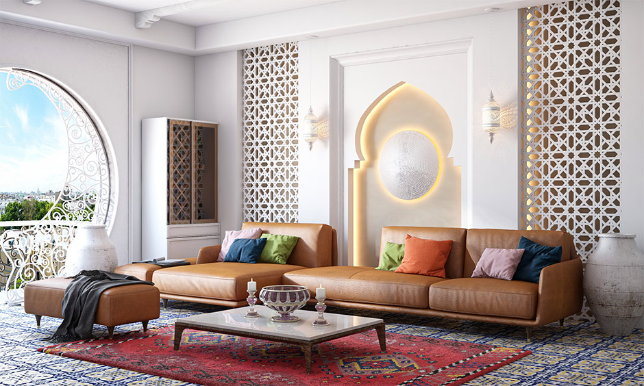 Modern Moroccan interior living room has an intricate cutwork wall and floor tiles in bold floral patterns.