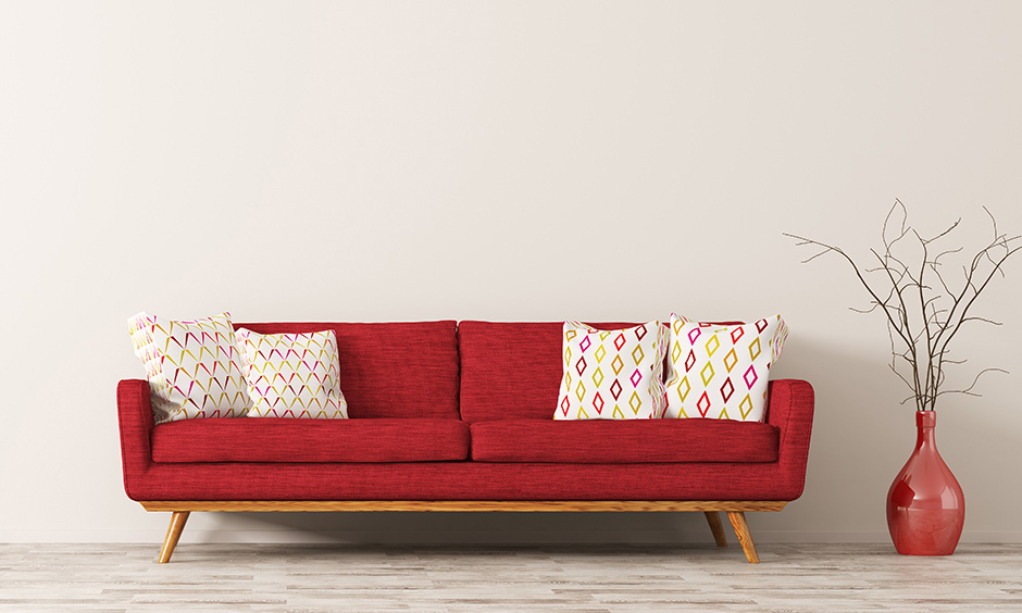 Tufted loveseat in red colour with wooden base adds a pristine natural look to the loveseat