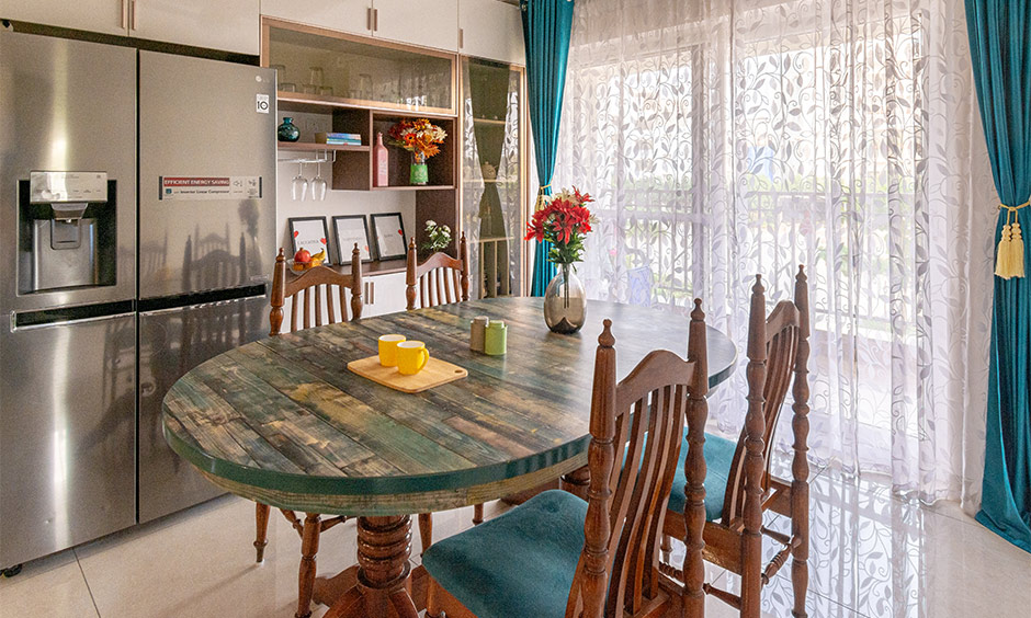 Traditional oval dining table with multicolour countertop with heavily ornated table legs gives old-world touch