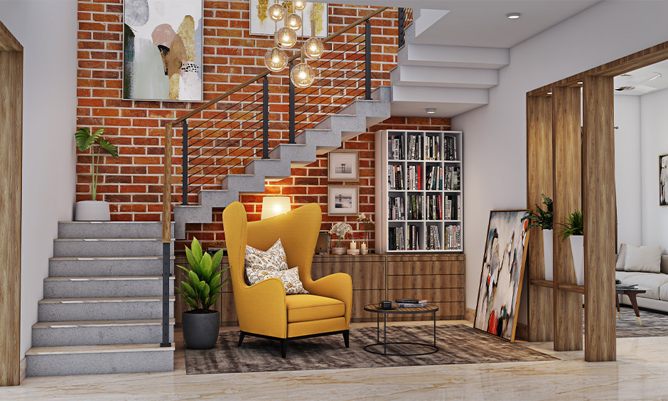 Bookshelf design under stairs creates a perfect reading corner with a wingback reading chair and a tiny coffee table