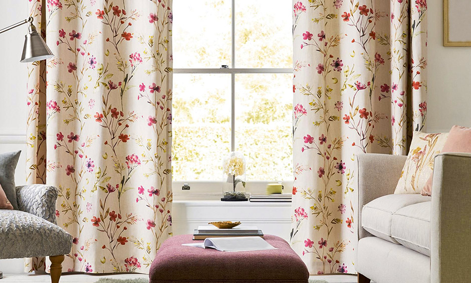 The luxury traditional living room has printed curtains with flowers that adorn the windows