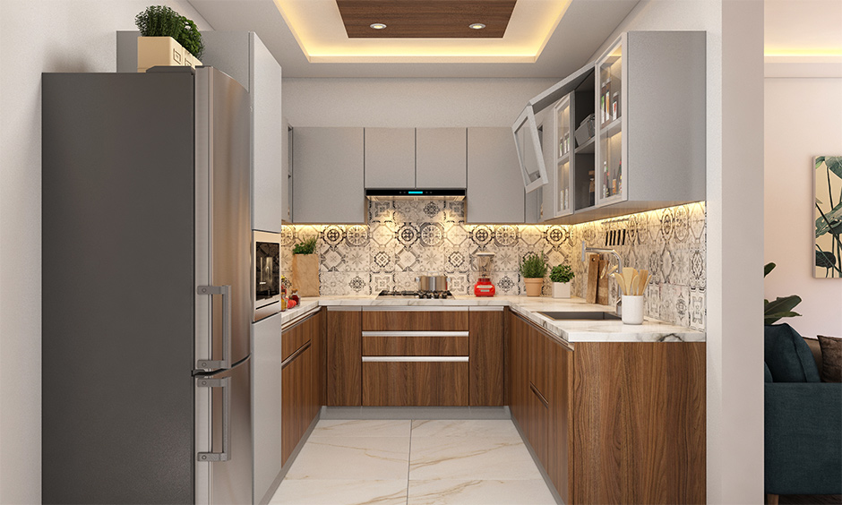 A small modern u shaped kitchen with beautiful lit false ceiling is perfect for compact houses