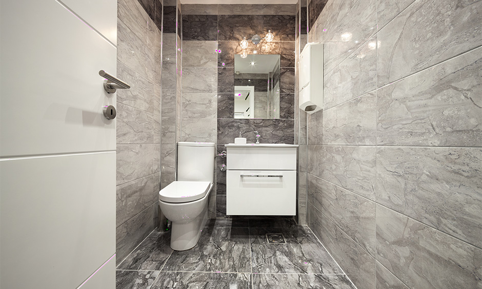 Black marble floor design elevates the look of a small bathroom