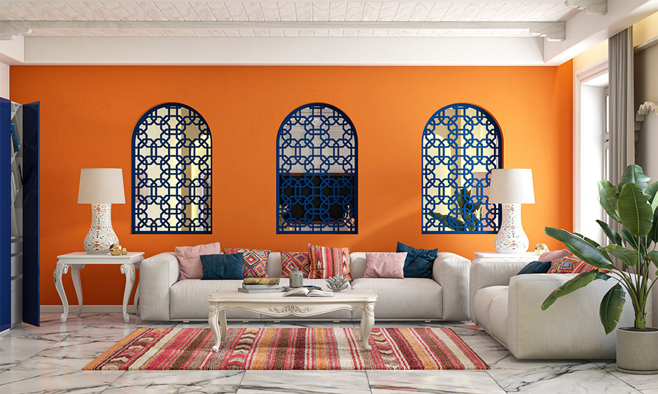 Bright orange colour for living room wall with blue windows and cabinet brings a traditional touch to space