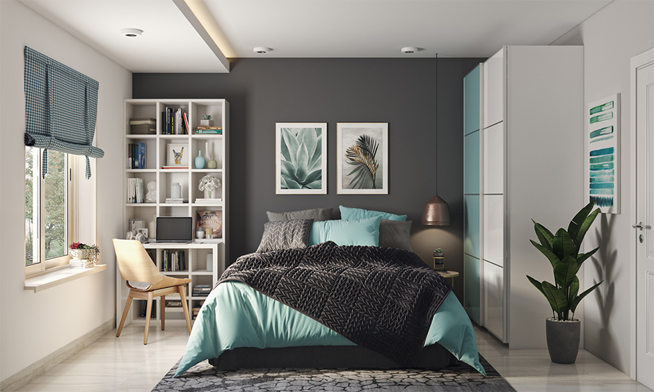 A dark grey bedroom with pops of teal complements the space