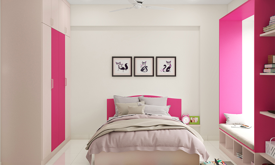 Girl's pink bedroom features a pink-coloured headboard and wardrobe with window seating