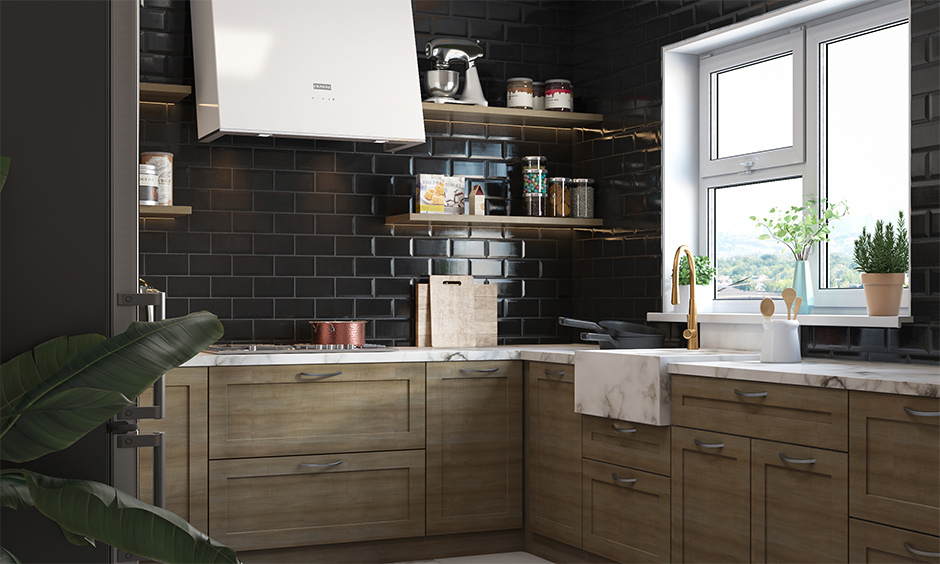 A small modular kitchen features a matte black wall tiles