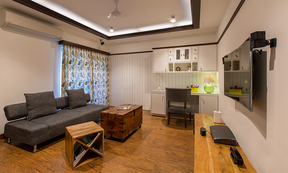 A storage bench made of wood doubles up as a coffee table in the living room