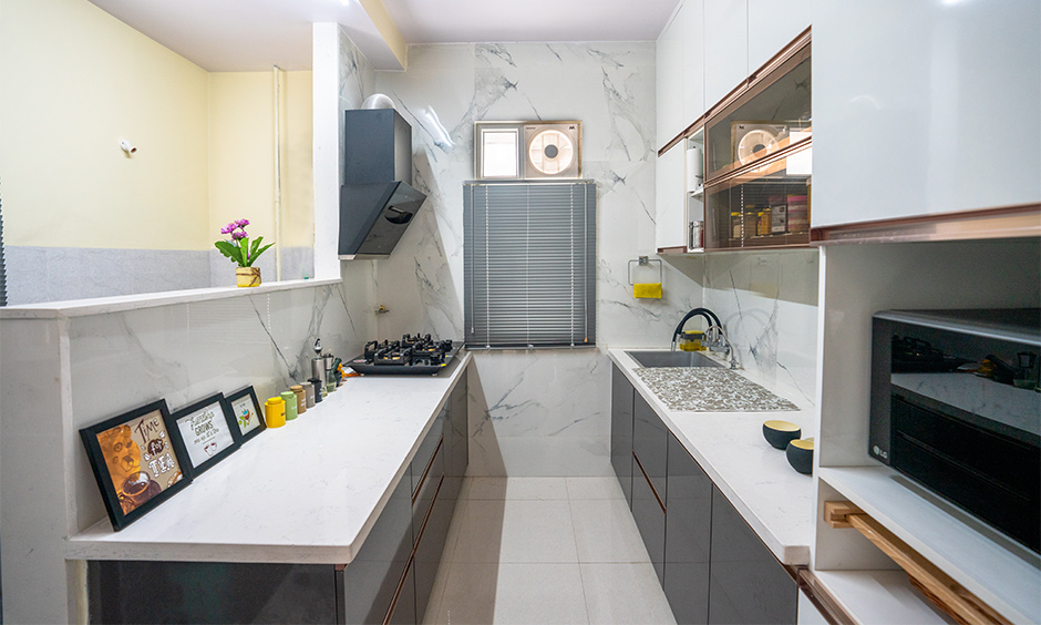 A galley kitchen with handleless storage cabinets as best interior designers in hyderabad