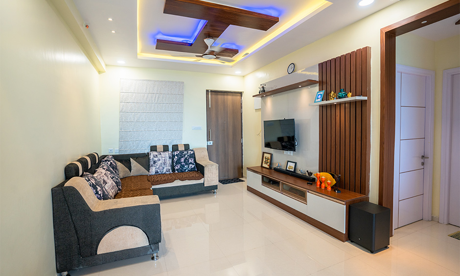 A spacious living room with sectional sofas and modular tv unit interior designers in hyderabad