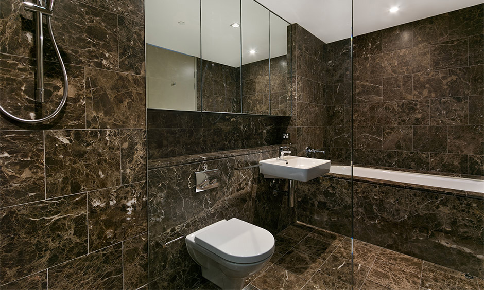 Black emperador italian marble flooring patterns for the bathroom which gives the space a premium look