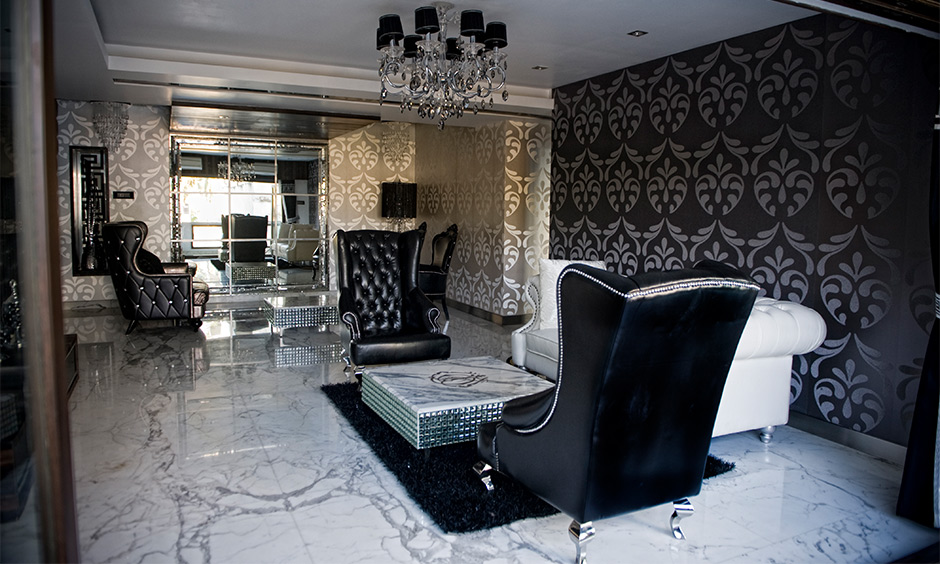 A black and white living room idea with wall prints, chandelier, and couches give a luxurious look