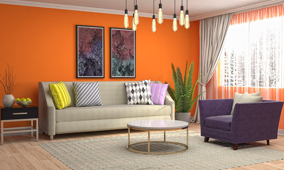 The grey colour of the curtain for the orange shade walls in the living room lends a modern look