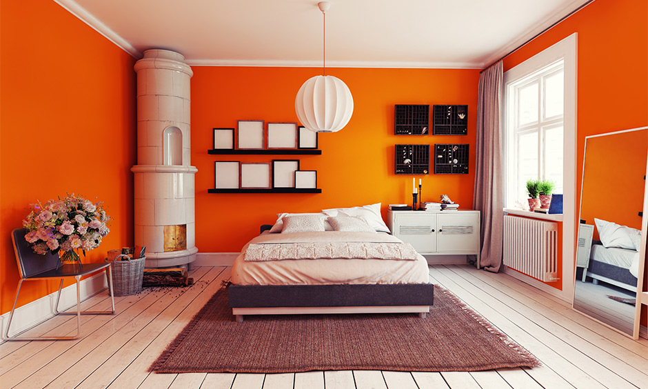 The grey curtain for the orange wall in the bedroom easily blends with the overall colour scheme