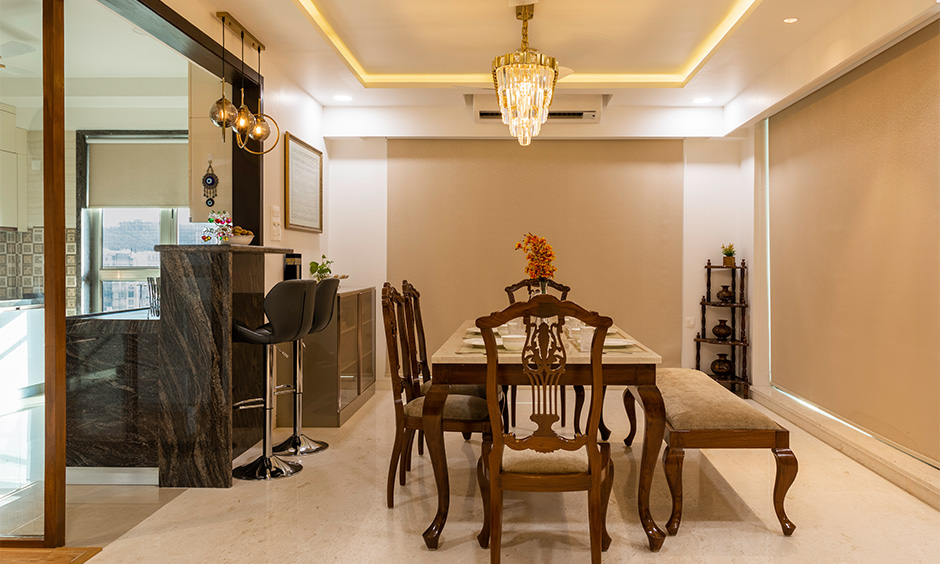 A regal dining room with a tall breakfast counter by famous interior designers in mumbai