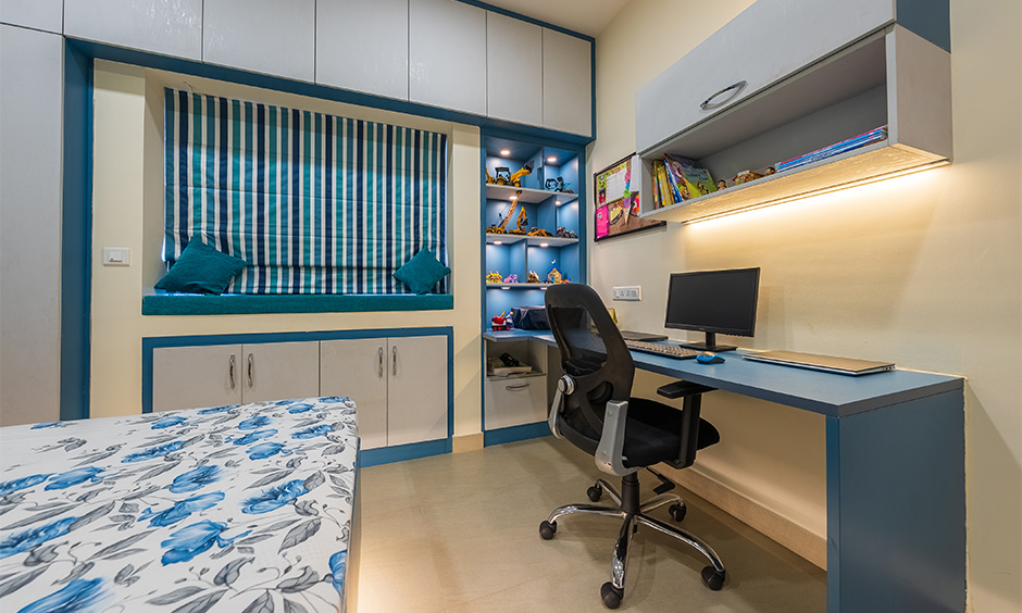 A bedroom with study table idea in blue and white theme attached to box shelf