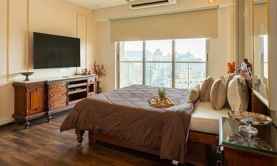 Guest bedroom with a stunning carved wooden tv unit by architects & interior designers in mumbai