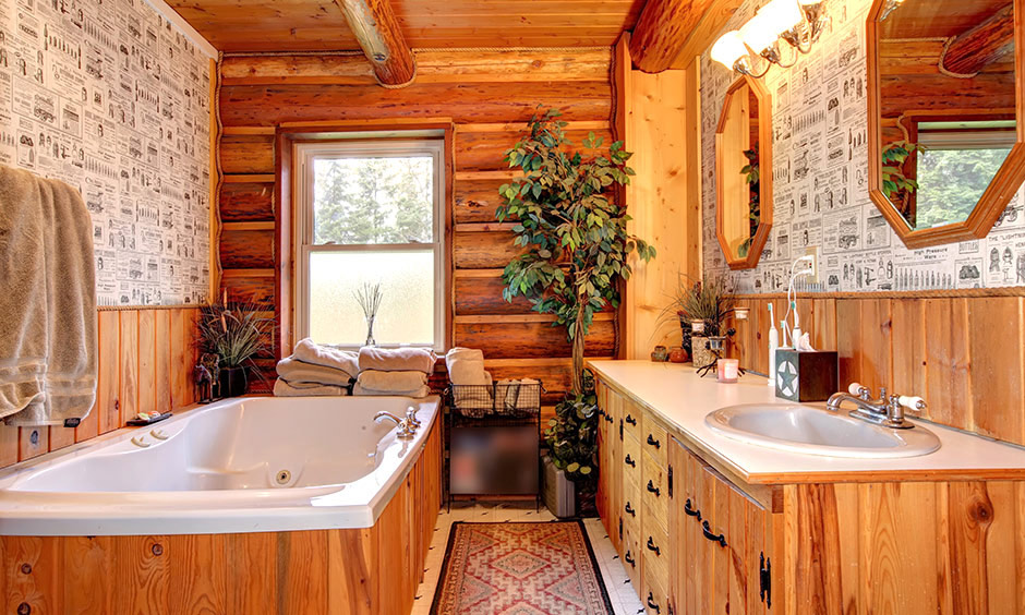 A wooden vanity sink with two mirrors and wallpapered bathroom walls