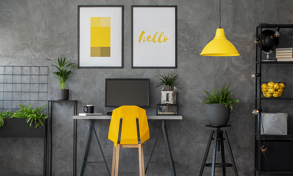 Bold desk chair in yellow color surrounded by indoor plants in grey room