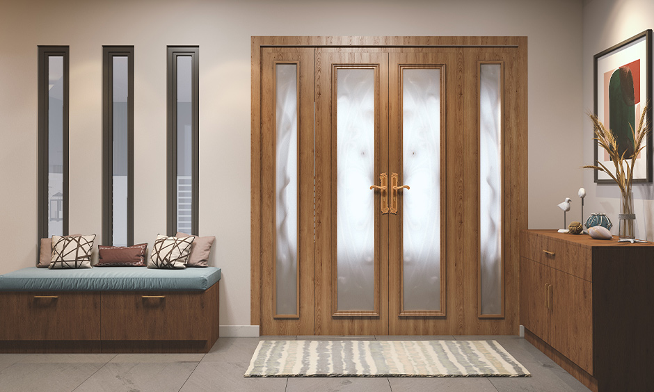 Wooden main double doors with frosted glass panels and polished brass handles